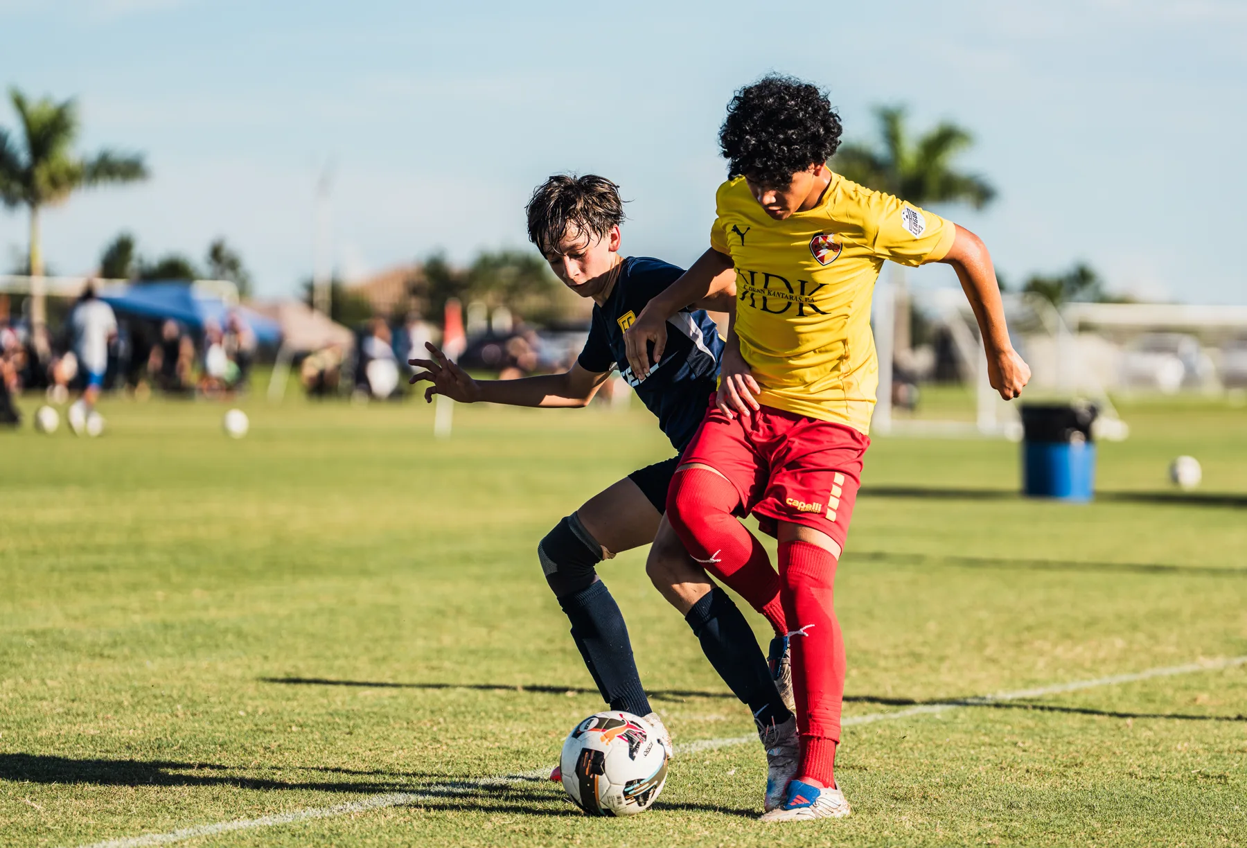 Two youth soccer players competing for the ball